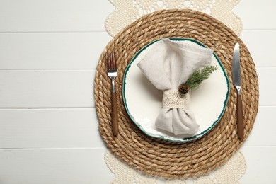 Photo of Christmas place setting with plate, cutlery and decor on white wooden table, top view. Space for text