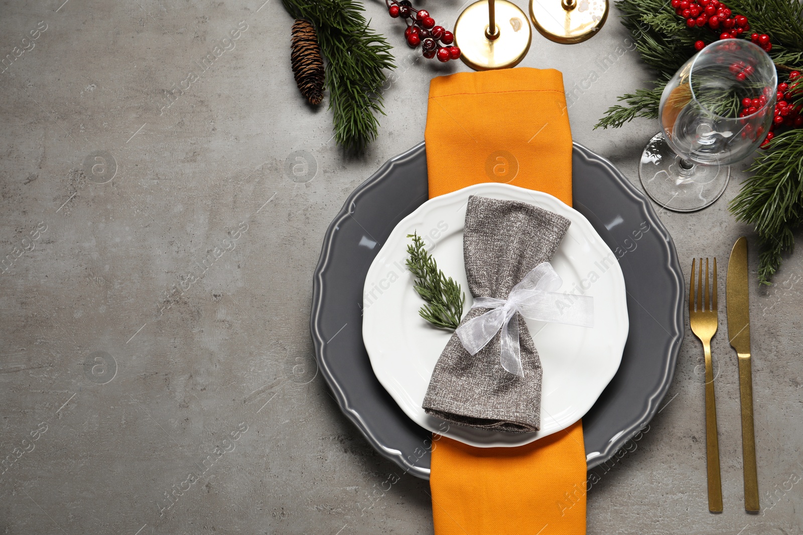 Photo of Christmas place setting with festive decor on grey table, flat lay. Space for text