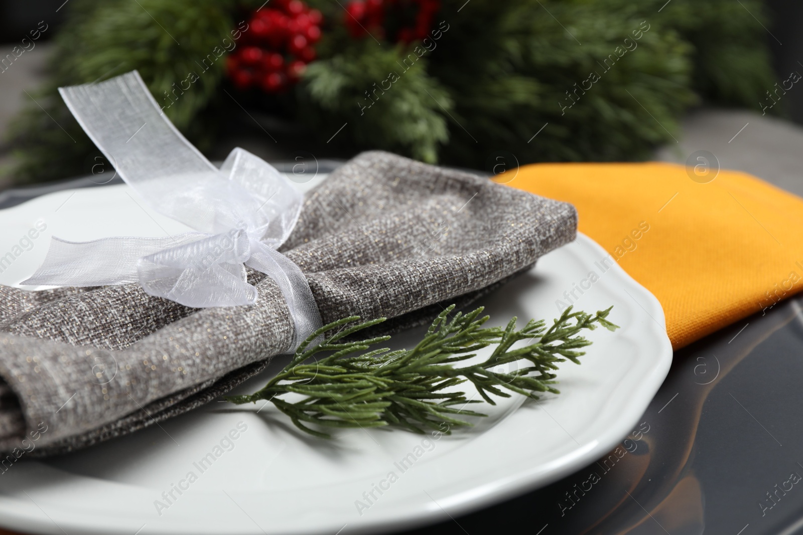 Photo of Christmas place setting with festive decor on table, closeup