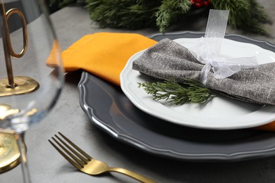 Photo of Christmas place setting with festive decor on grey table, closeup