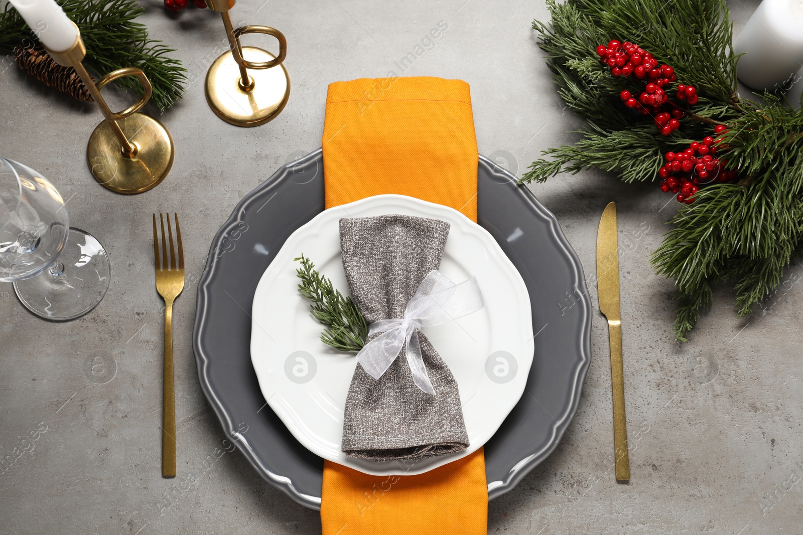 Photo of Christmas place setting with festive decor on grey table, flat lay