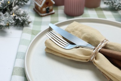 Photo of Christmas place setting with festive decor on white table, closeup