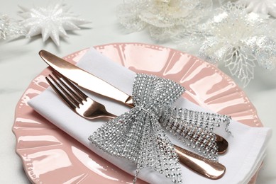 Photo of Christmas place setting with festive decor on white table, closeup