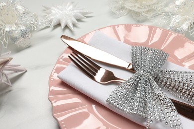 Photo of Christmas place setting with festive decor on white table, closeup