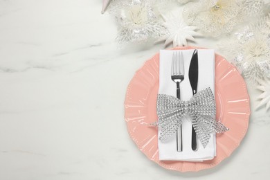 Photo of Christmas place setting with festive decor on white marble table, flat lay. Space for text