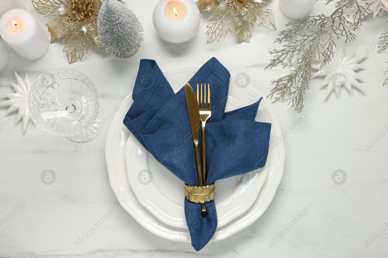 Photo of Christmas place setting with festive decor on white marble table, flat lay