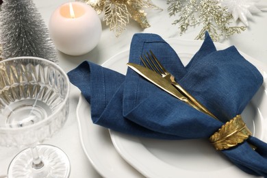 Photo of Christmas place setting with festive decor on white table, closeup