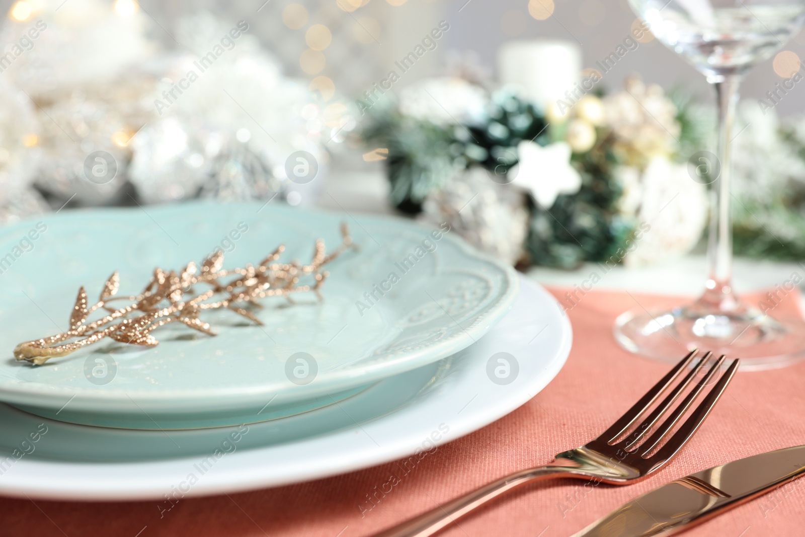 Photo of Christmas place setting with plates, cutlery and festive decor on table, closeup