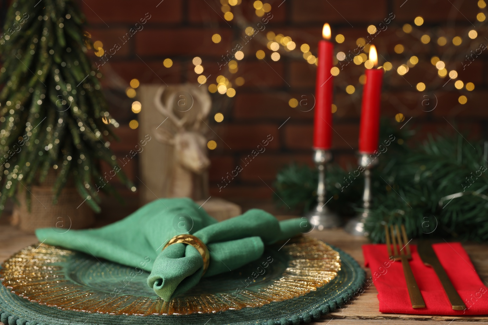 Photo of Christmas place setting with festive decor on wooden table, closeup