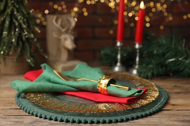 Photo of Christmas place setting with festive decor on wooden table, closeup