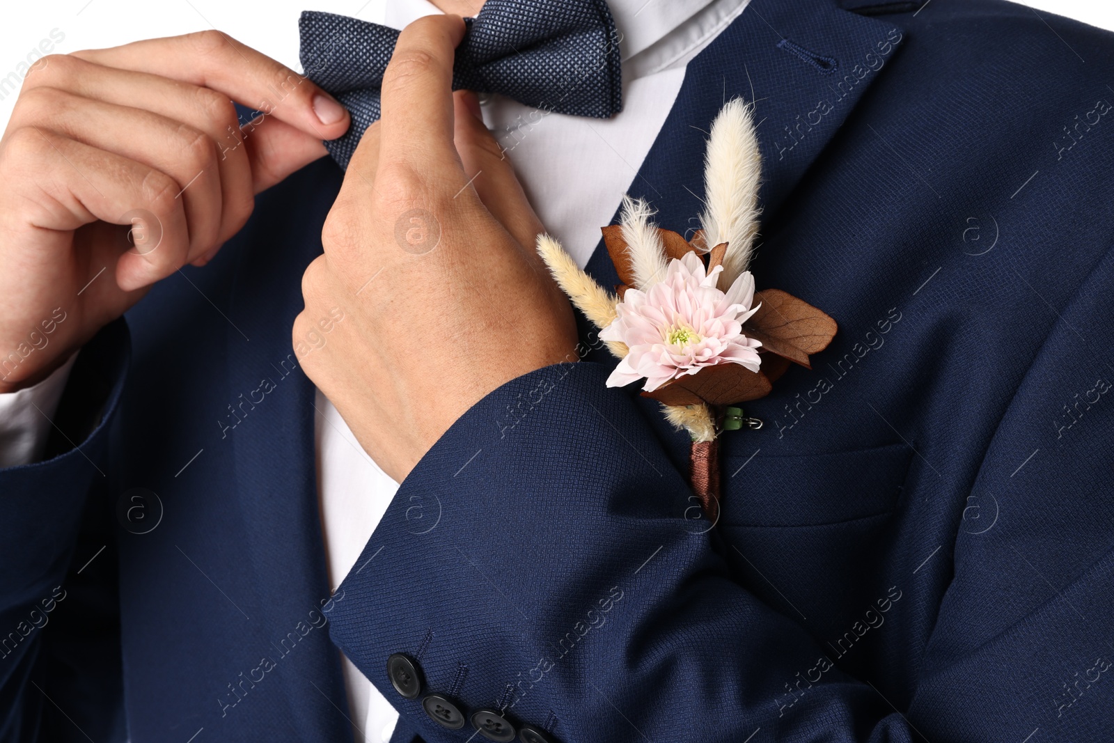 Photo of Groom in suit with stylish boutonniere on white background, closeup