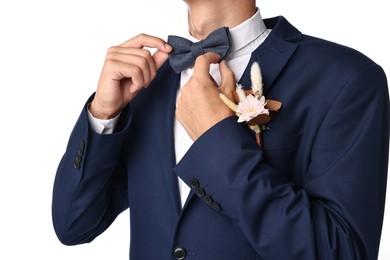 Photo of Groom in suit with stylish boutonniere on white background, closeup