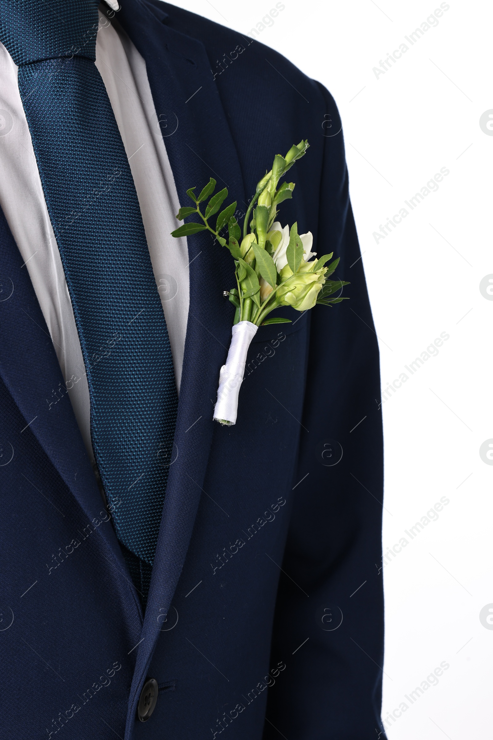 Photo of Groom in suit with stylish boutonniere on white background, closeup