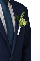 Groom in suit with stylish boutonniere on white background, closeup