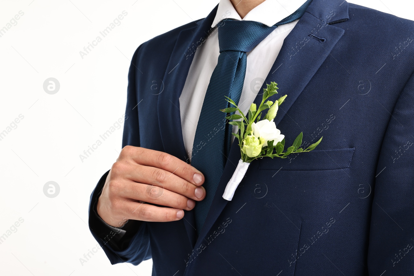 Photo of Groom in suit with stylish boutonniere on white background, closeup