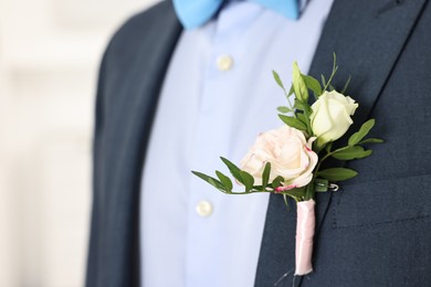 Photo of Groom in suit with stylish boutonniere indoors, closeup