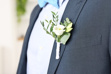 Photo of Groom in suit with stylish boutonniere indoors, closeup