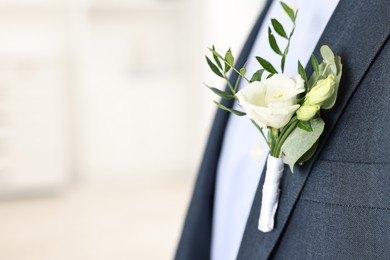 Photo of Groom in suit with stylish boutonniere indoors, closeup. Space for text