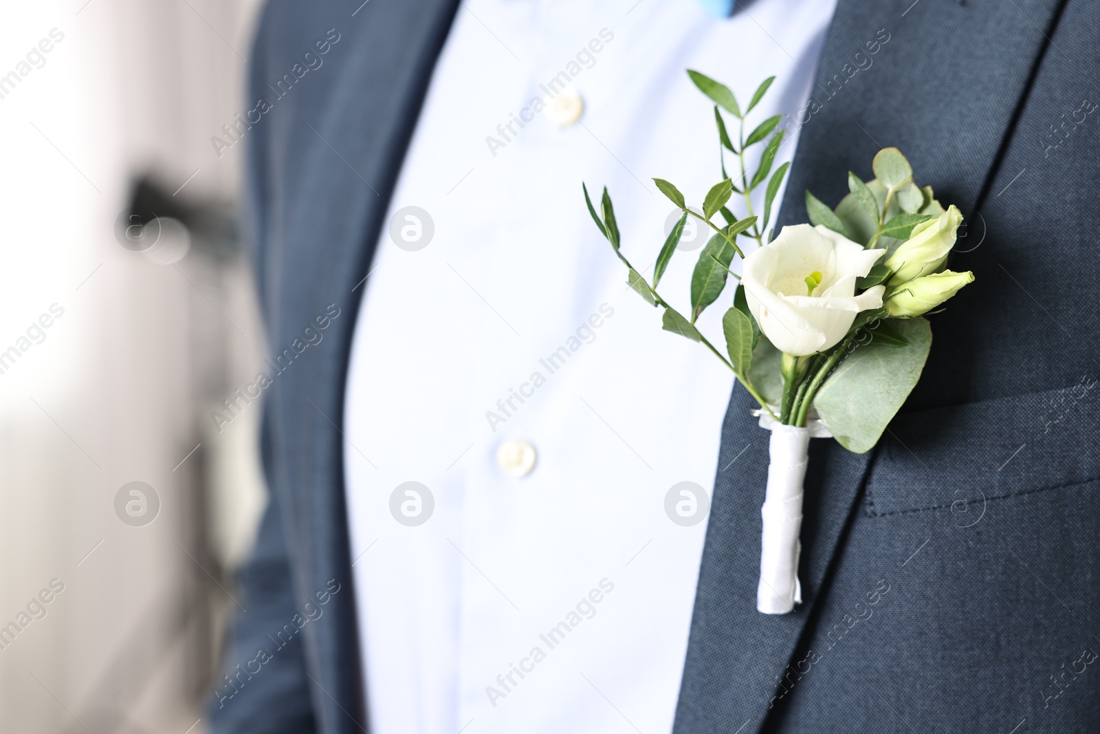 Photo of Groom in suit with stylish boutonniere indoors, closeup