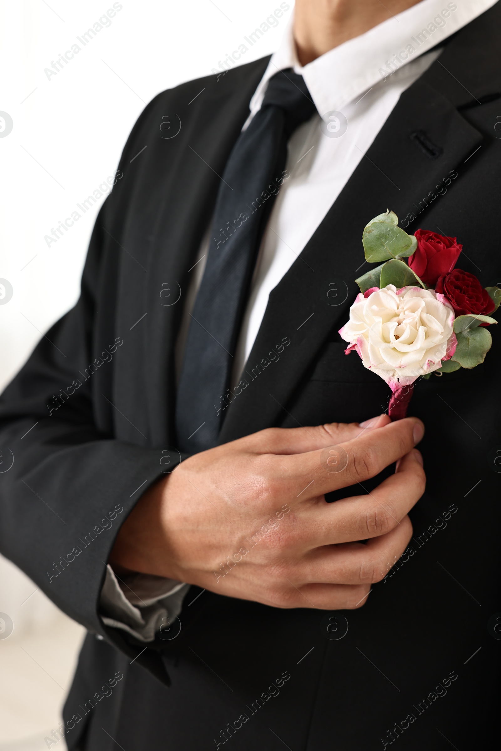 Photo of Groom in suit with stylish boutonniere indoors, closeup