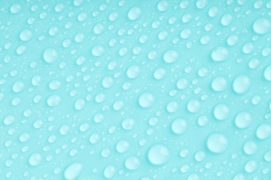 Photo of Water drops on turquoise background, top view