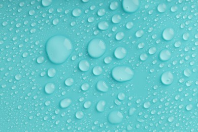 Photo of Water drops on turquoise background, top view