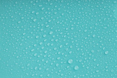 Photo of Water drops on turquoise background, top view