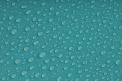 Photo of Water drops on turquoise background, top view