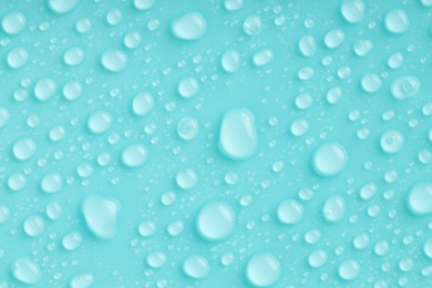 Photo of Water drops on turquoise background, top view