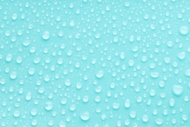 Photo of Water drops on turquoise background, top view