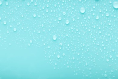 Photo of Water drops on turquoise background, top view