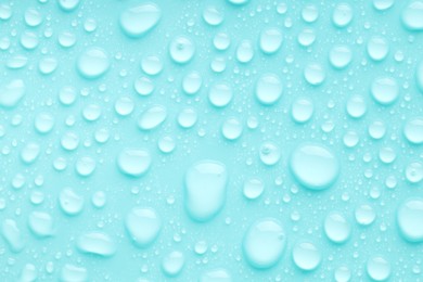 Photo of Water drops on turquoise background, top view