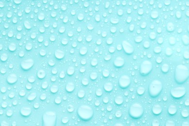 Photo of Water drops on turquoise background, top view