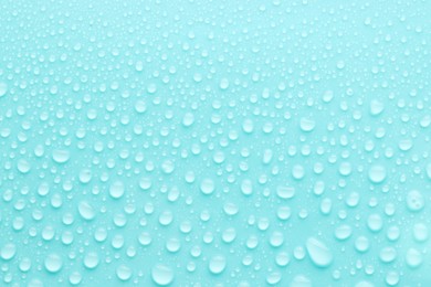 Photo of Water drops on turquoise background, top view