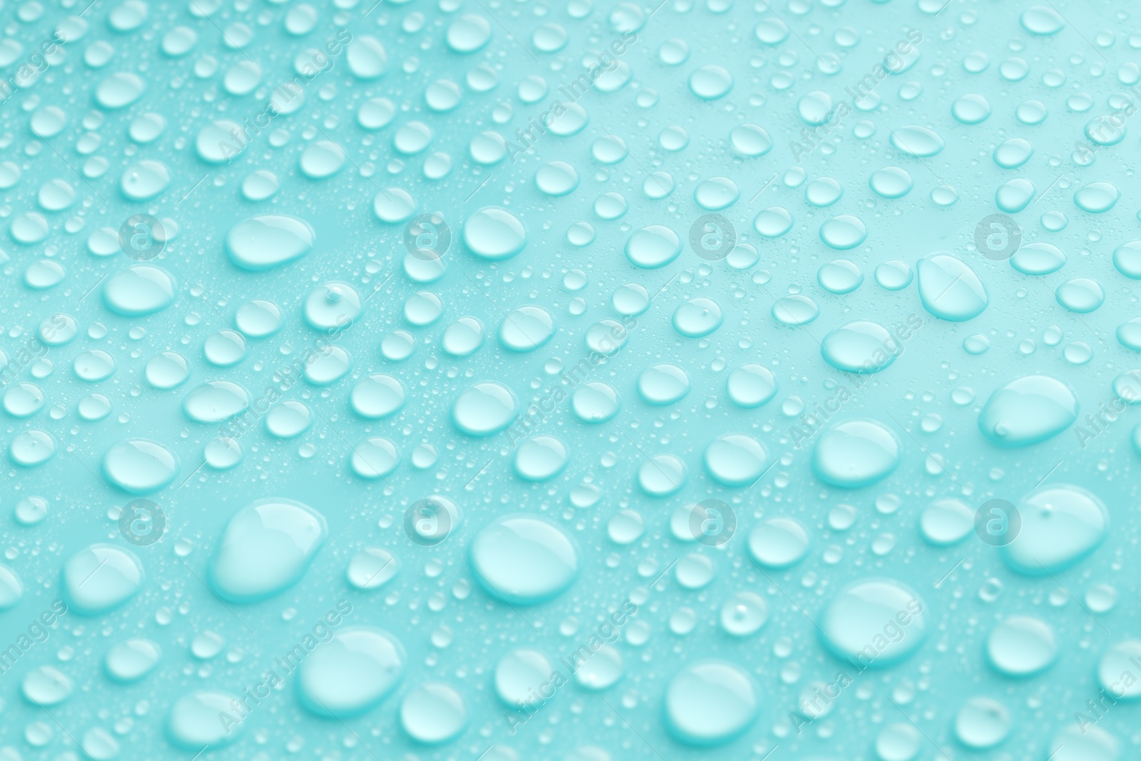 Photo of Water drops on turquoise background, closeup view