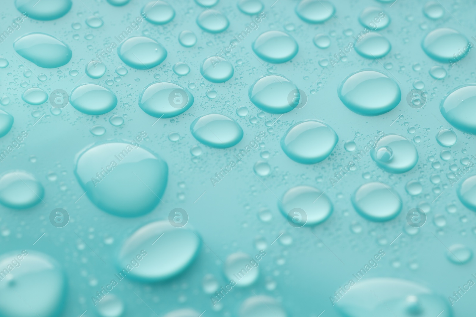 Photo of Water drops on turquoise background, closeup view