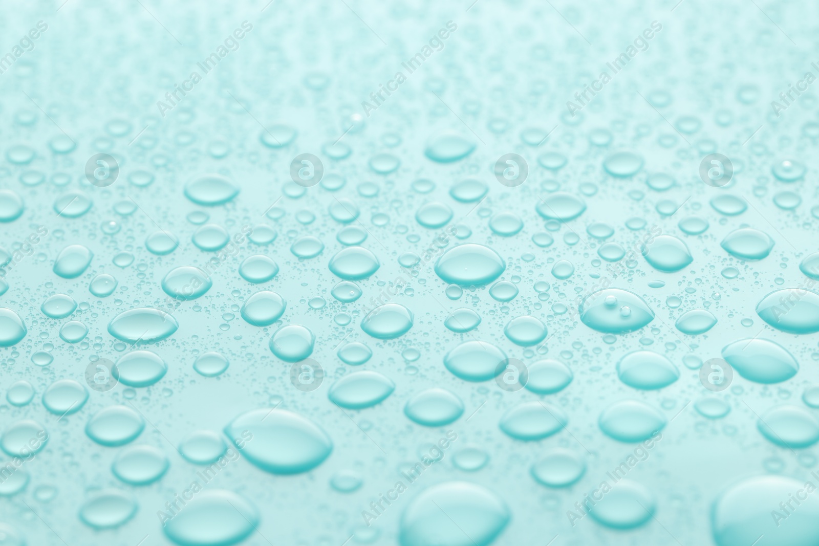 Photo of Water drops on turquoise background, closeup view