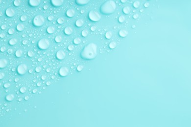 Photo of Water drops on turquoise background, top view. Space for text