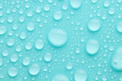 Photo of Water drops on turquoise background, top view