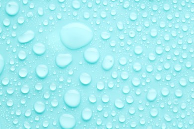 Photo of Water drops on turquoise background, top view