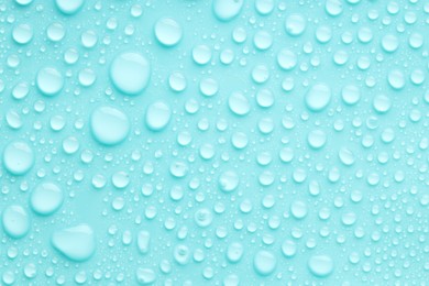 Photo of Water drops on turquoise background, top view