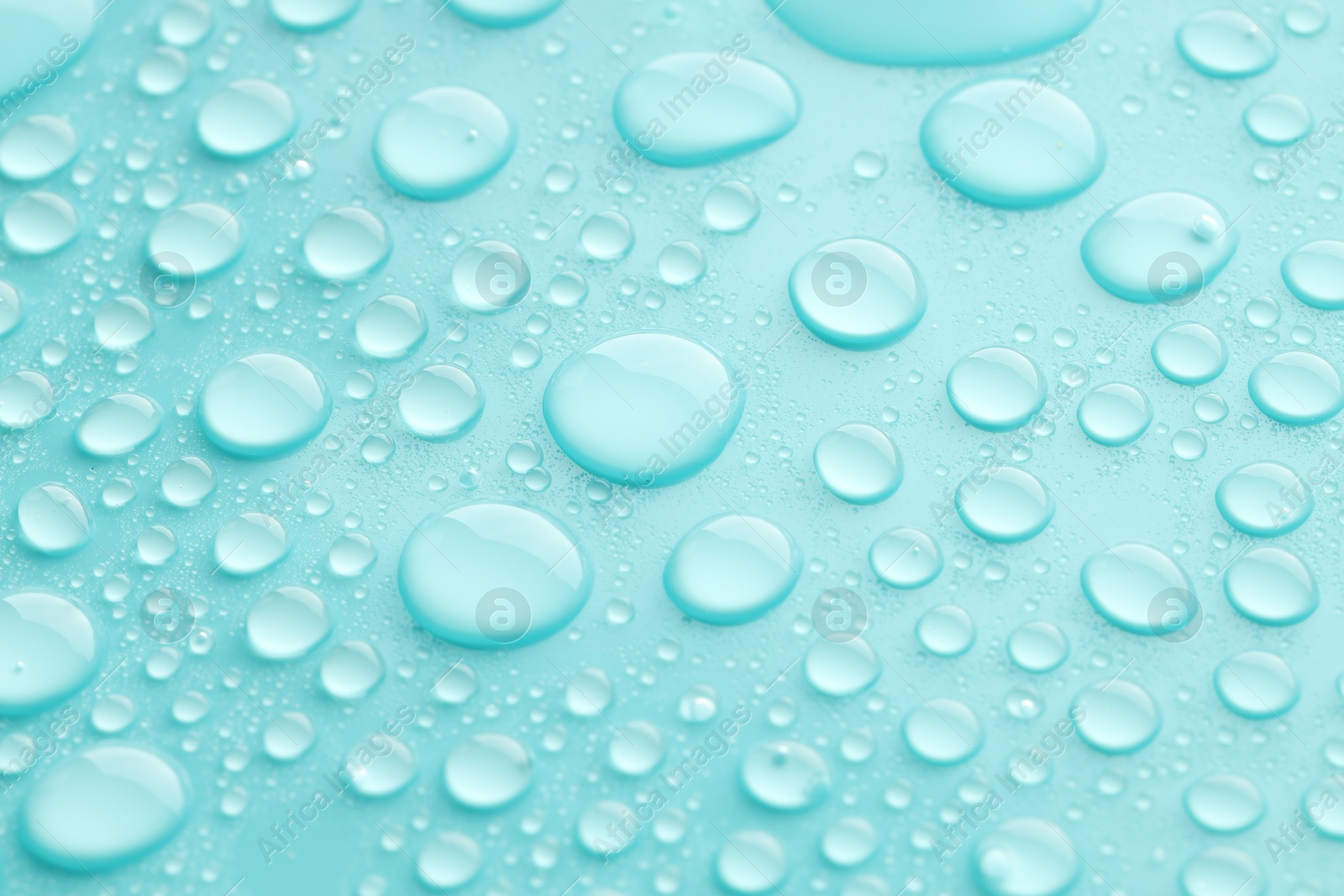 Photo of Water drops on turquoise background, closeup view