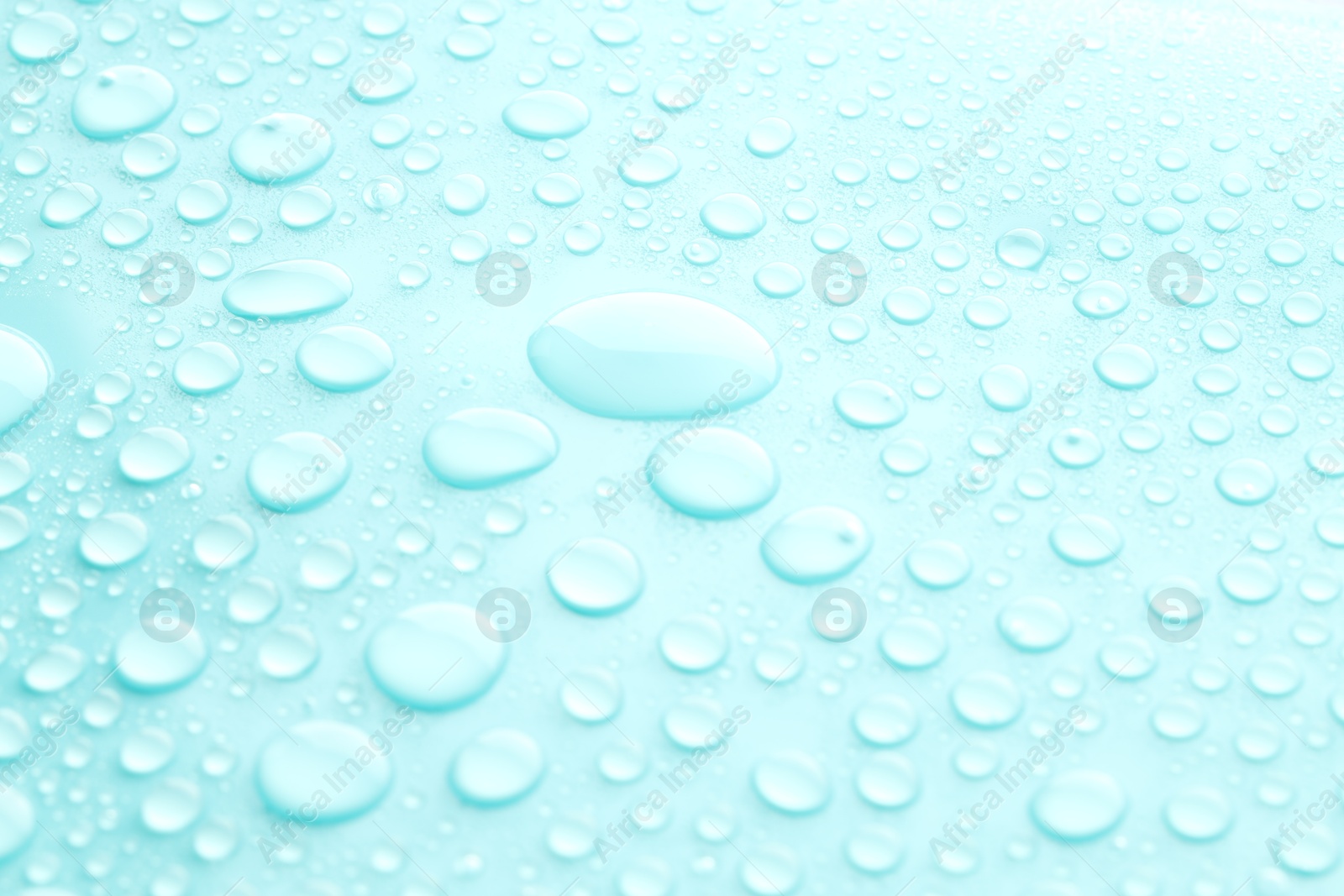 Photo of Water drops on turquoise background, closeup view