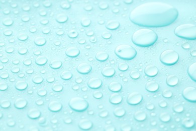 Photo of Water drops on turquoise background, closeup view