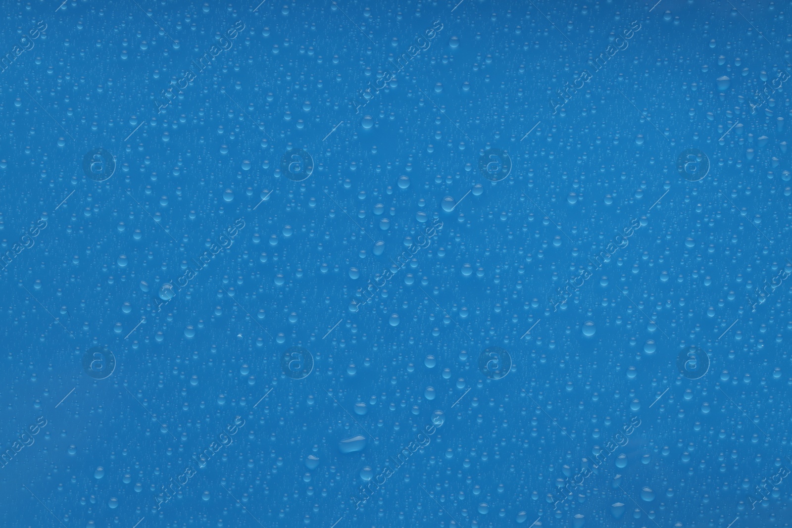 Photo of Water drops on blue background, top view