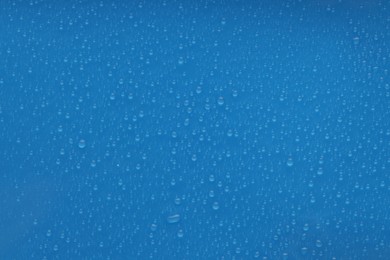 Photo of Water drops on blue background, top view