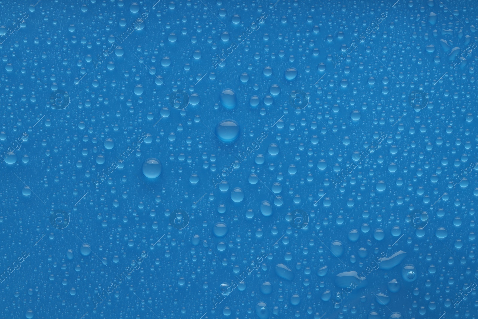 Photo of Water drops on blue background, top view