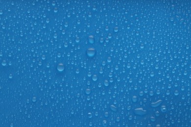 Photo of Water drops on blue background, top view