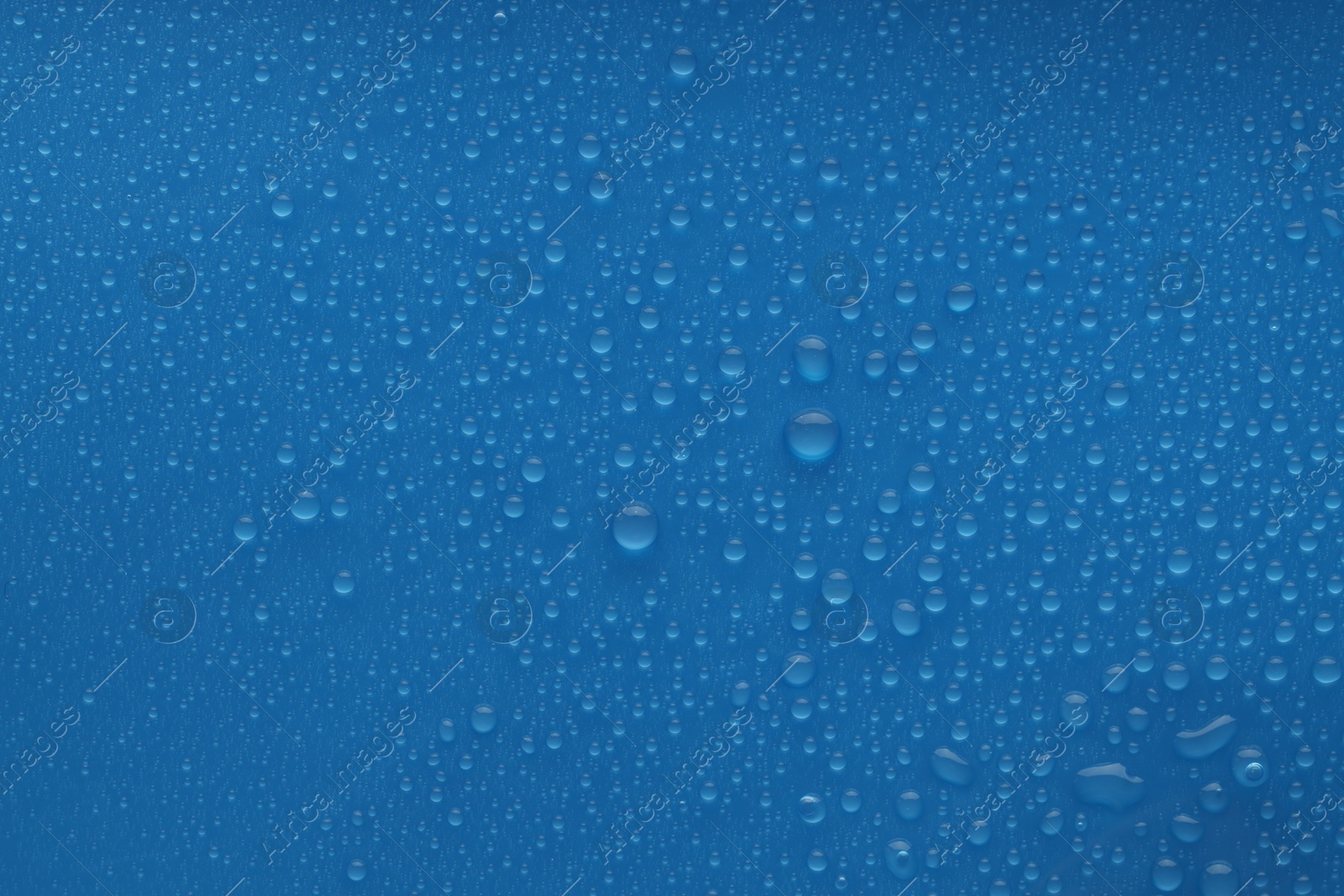 Photo of Water drops on blue background, top view