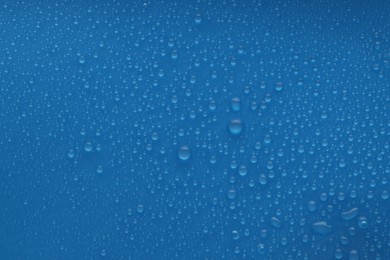 Photo of Water drops on blue background, top view